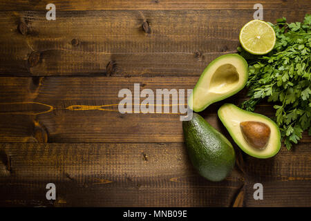 Avocado su legno scuro dello sfondo. Cibo sano concetto. Foto Stock