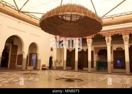 Il Museo di Marrakech è alloggiato nel modulo DAR Menebhi Palace. L'atrio ha un lampadario a bracci costituiti da piastre di metallo decorato con tagli geometrici Foto Stock