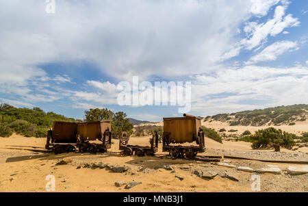 Vecchie e arrugginite carrelli di miniera a cielo aperto sulla sabbia in Sardegna. Ingortosu's mine Foto Stock