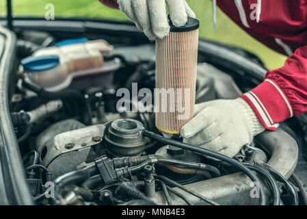 Il meccanico automatico sostituisce la vettura del filtro olio. Foto Stock