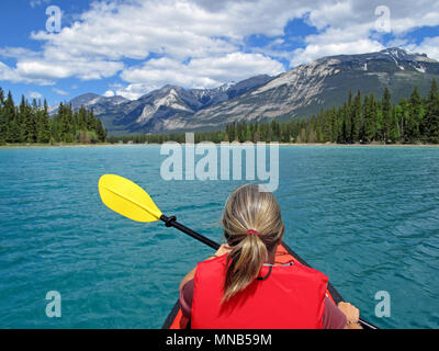 Donna con kayak gonfiabili rosso kayak sul lago di Edith, Jasper, montagne rocciose, Canada Foto Stock