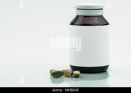 Vitamine, supplementi minerali e dual layer compresse pillole e medicina flacone di vetro ambrato con etichetta vuota isolata su sfondo bianco con copia sp Foto Stock