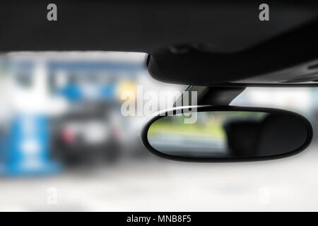 Specchio auto visto dall'interno di un automobile e uno sfondo sfocato. Messa a fuoco selettiva. Close up. Foto Stock