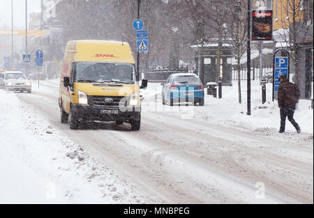 Karlstad, Svezia - 30 Gennaio 2014: UN GIALLO DHL di consegna pacchi van guida su strada Ostra Torgatan con l'inverno alle condizioni della strada nella città cen Foto Stock