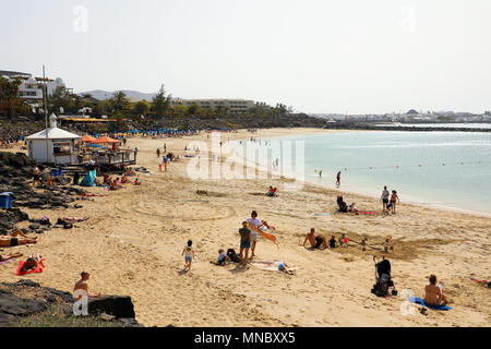 LANZAROTE, Spagna: 18 Aprile 2018: la splendida vista di Playa Dorada Beach con i bagnanti sulla sabbia, Lanzarote, Isole Canarie Foto Stock