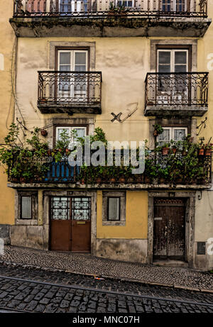 La facciata della casa di città con più di balconi in ferro battuto su una ripida strada di ciottoli in Martim Moniz Foto Stock