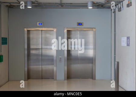 Chiuso ascensori con pulsanti in corridoio con pareti in calcestruzzo. Concetto di office center interno Foto Stock