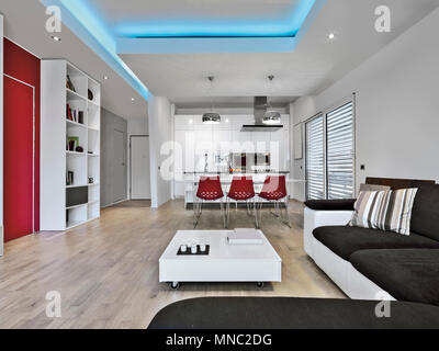 PROGETTO G. VAZZOLA scatti di interni di un soggiorno moderno che si affaccia sul tavolo da pranzo e la cucina il pavimento è di legno duro Foto Stock