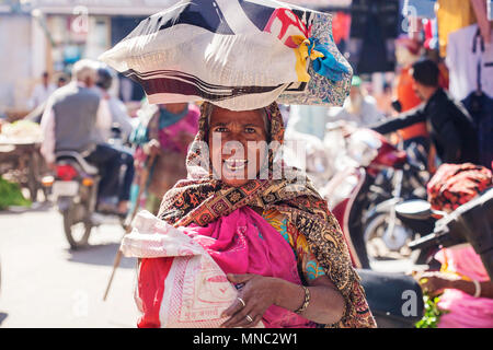 Udaipur città, Rajasthan, India, 9 Febbraio 2018: donna indiana lo shopping al mercato ortofrutticolo con un sacchetto sul suo capo Foto Stock