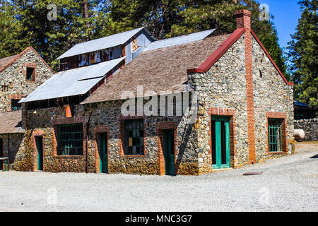 Angolo edificio in pietra con Rusty Tin Roof Foto Stock