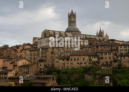 Sito del Patrimonio mondiale Siena Italia vista panoramica della città con la sua magnifica architettura medievale e la cupola e antichi tetti contro un cielo tempestoso Foto Stock