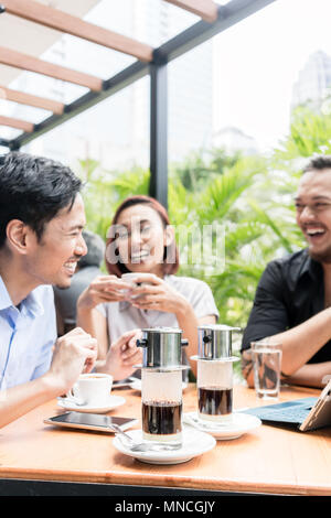 Caffè vietnamita serviti al tavolo dei tre amici all'aperto Foto Stock