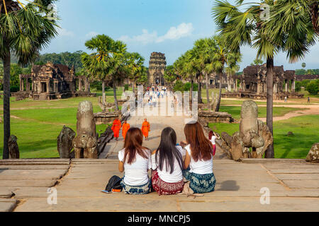 Turisti femmina resto sulla scalinata che conduce al tempio principale complesso di Angkor Wat in Siem Reap, Cambogia. Foto Stock