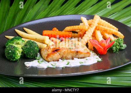 Bistecca di salmone sulla piastra con corn chips e pomodori. Foto Stock