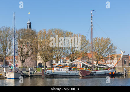 Enkhuizen, Paesi Bassi - 20 Aprile 2018: Tradizionale chiatta nel porto di Enkhuizen con persone di relax al sole Foto Stock