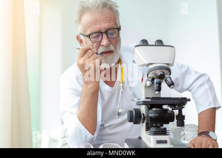 Medico i vecchi o gravemente scienziato che lavora con un microscopio in laboratorio. Foto Stock