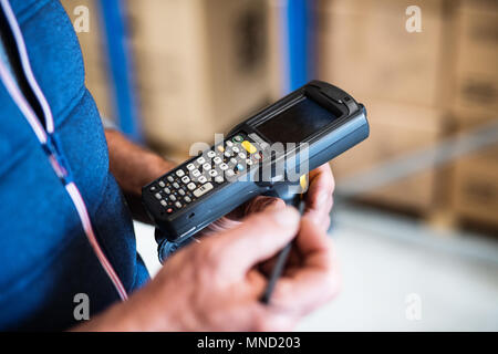 Magazzino maschio lavoratore con uno scanner di codici a barre. Foto Stock