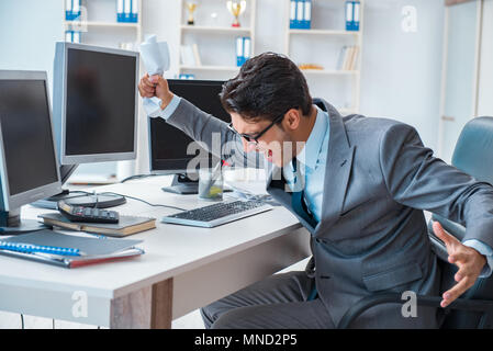 Imprenditore seduto di fronte a molte schermate Foto Stock