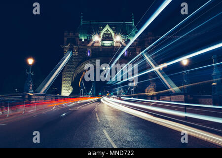 Città sentieri di luce del traffico sul Ponte della Torre di Londra di notte Foto Stock