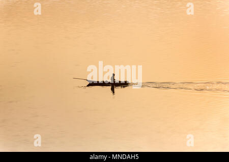 Pescatore in barca a remi sulla bara Pani lago a sunrise, Siloe, Meghalaya, India Foto Stock