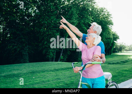 Caucasian coppia di anziani mano di puntamento a lato Foto Stock