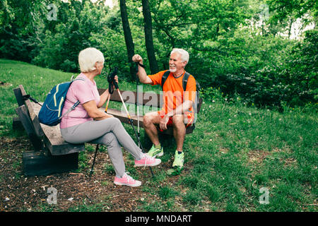Coppia senior gli escursionisti con pali in appoggio Foto Stock