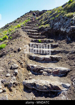 Una femmina di walker salendo un ripido sentiero a gradini in alto sopra Hermigua sulla costa nord di La Gomera nelle isole Canarie Foto Stock