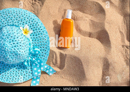 Crema solare, cappello sulla sabbia, concetto di vacanza estiva, un ottica con un posto per il vostro testo Foto Stock