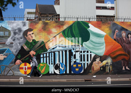 Un uomo cammina oltre la pace internazionale sulla parete Falls Road, West Belfast, maggio 2018. Falls Road (Irish túath na bhFál, il significato di "territorio dell'enclosure) è la strada principale attraverso la parte occidentale di Belfast, Irlanda del Nord, in esecuzione da Divis Street a Belfast City Centre a Andersonstown nei sobborghi. Il suo nome è sinonimo con la comunità repubblicana nella città, mentre la vicina Shankill Road è prevalentemente lealisti, separati da Falls Road da linee di pace. La strada è in genere indicato come Falls Road, piuttosto che come Falls Road. È noto come la Faas Raa in Ulste Foto Stock