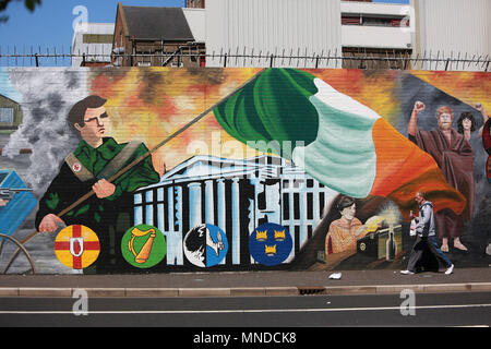 Un uomo cammina oltre la pace internazionale sulla parete Falls Road, West Belfast, maggio 2018. Falls Road (Irish túath na bhFál, il significato di "territorio dell'enclosure) è la strada principale attraverso la parte occidentale di Belfast, Irlanda del Nord, in esecuzione da Divis Street a Belfast City Centre a Andersonstown nei sobborghi. Il suo nome è sinonimo con la comunità repubblicana nella città, mentre la vicina Shankill Road è prevalentemente lealisti, separati da Falls Road da linee di pace. La strada è in genere indicato come Falls Road, piuttosto che come Falls Road. È noto come la Faas Raa in Ulste Foto Stock