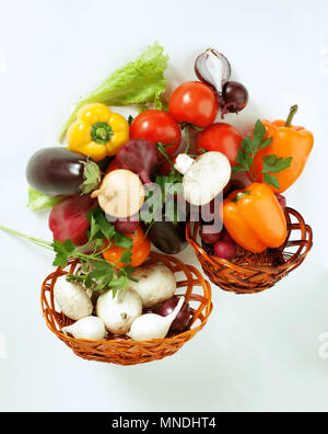 Funghi e una varietà di verdure fresche in un cesto di vimini.isolato su un bianco Foto Stock