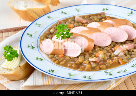 Sostanzioso stufato di lenticchie con frankfurters (Wiener) e baguette Foto Stock