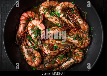 Tiger Gamberi fritti in padella. Ricetta classica - prezzemolo, aglio, peperoncino e vino bianco. Foto Stock