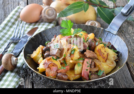 Patate fritte con carne di manzo, pancetta e champignon (cosiddetto "tirolese groestl'), spesso servito in una padella Foto Stock