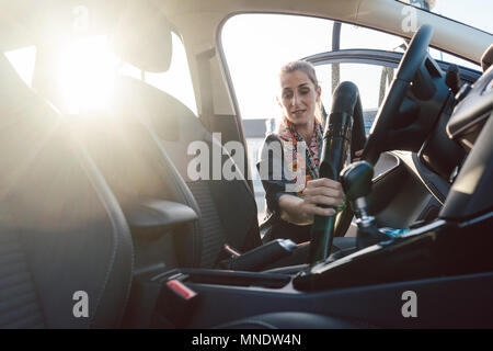 Pulizia donna, aspirazione interna dell'auto con aspirapolvere, concetto di  trasporto Foto stock - Alamy