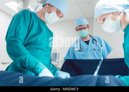 Medico Chirurgico in piena concentrazione sul funzionamento Foto Stock