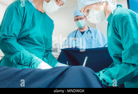 Medico Chirurgico in piena concentrazione sul funzionamento Foto Stock