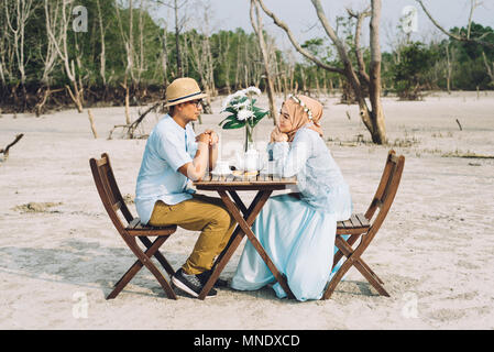 Bella coppia asiatica avente un romantico momento di felicità per esterno con tavolo da picnic e sedia. amore e concetto di datazione. L'immagine orizzontale Foto Stock