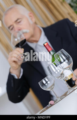 L uomo lo sniffing vino rosso in vetro Foto Stock