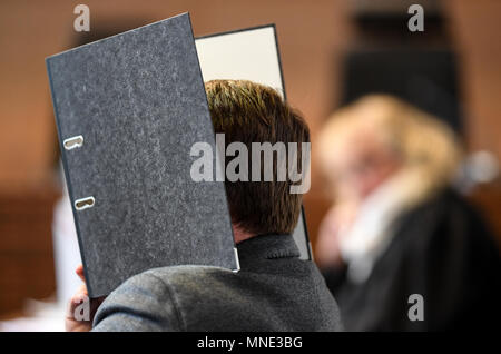 16 maggio 2018, Germania, Friburgo: Knut S., accusati di abusi sui minori, seduti in una sala del tribunale distrettuale e tenendo una cartella nella parte anteriore del suo volto. Un verdetto verrà passata per il caso di oggi. Il soldato da forze armate tedesche, che hanno trasformato il cinquanta oggi, è accusato di aver violentato un ragazzo due volte l'anno scorso nella città di Staufen vicino a Friburgo. Egli è stato anche accusato di filmatura della legge e di inviarlo ad altri. Foto: Patrick Seeger/dpa Foto Stock