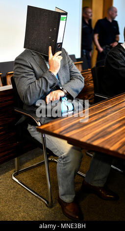 16 maggio 2018, Germania, Friburgo: Knut S., accusati di abusi sui minori, seduti in una sala del tribunale distrettuale e tenendo una cartella nella parte anteriore del suo volto. Un verdetto verrà passata per il caso di oggi. Il soldato da forze armate tedesche, che hanno trasformato il cinquanta oggi, è accusato di aver violentato un ragazzo due volte l'anno scorso nella città di Staufen vicino a Friburgo. Egli è stato anche accusato di filmatura della legge e di inviarlo ad altri. Foto: Patrick Seeger/dpa Foto Stock
