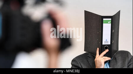 16 maggio 2018, Germania, Friburgo: Knut S., accusati di abusi sui minori, seduti in una sala del tribunale distrettuale e tenendo una cartella nella parte anteriore del suo volto. Un verdetto verrà passata per il caso di oggi. Il soldato da forze armate tedesche, che hanno trasformato il cinquanta oggi, è accusato di aver violentato un ragazzo due volte l'anno scorso nella città di Staufen vicino a Friburgo. Egli è stato anche accusato di filmatura della legge e di inviarlo ad altri. Foto: Patrick Seeger/dpa Foto Stock