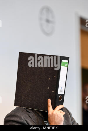 16 maggio 2018, Germania, Friburgo: Knut S., accusati di abusi sui minori, seduti in una sala del tribunale distrettuale e tenendo una cartella nella parte anteriore del suo volto. Un verdetto verrà passata per il caso di oggi. Il soldato da forze armate tedesche, che hanno trasformato il cinquanta oggi, è accusato di aver violentato un ragazzo due volte l'anno scorso nella città di Staufen vicino a Friburgo. Egli è stato anche accusato di filmatura della legge e di inviarlo ad altri. Foto: Patrick Seeger/dpa Foto Stock