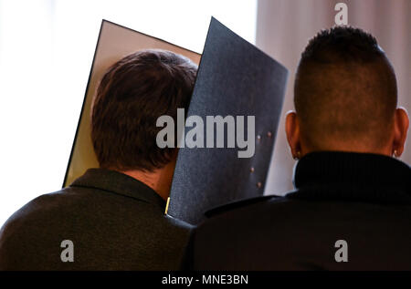 16 maggio 2018, Germania, Friburgo: Knut S., accusati di abusi sui minori, essendo portato in una sala del tribunale distrettuale da parte di un ufficiale giudiziario whislt tenendo una cartella nella parte anteriore del suo volto. Un verdetto verrà passata per il caso di oggi. Il soldato da forze armate tedesche, che hanno trasformato il cinquanta oggi, è accusato di aver violentato un ragazzo due volte l'anno scorso nella città di Staufen vicino a Friburgo. Egli è stato anche accusato di filmatura della legge e di inviarlo ad altri. Foto: Patrick Seeger/dpa Foto Stock