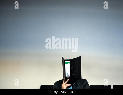 16 maggio 2018, Germania, Friburgo: Knut S., accusati di abusi sui minori, seduti in una sala del tribunale distrettuale e tenendo una cartella nella parte anteriore del suo volto. Un verdetto verrà passata per il caso di oggi. Il soldato da forze armate tedesche, che hanno trasformato il cinquanta oggi, è accusato di aver violentato un ragazzo due volte l'anno scorso nella città di Staufen vicino a Friburgo. Egli è stato anche accusato di filmatura della legge e di inviarlo ad altri. Foto: Patrick Seeger/dpa Foto Stock