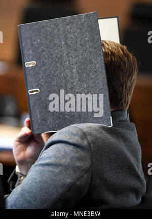 16 maggio 2018, Germania, Friburgo: Knut S., accusati di abusi sui minori, seduti in una sala del tribunale distrettuale e tenendo una cartella nella parte anteriore del suo volto. Un verdetto verrà passata per il caso di oggi. Il soldato da forze armate tedesche, che hanno trasformato il cinquanta oggi, è accusato di aver violentato un ragazzo due volte l'anno scorso nella città di Staufen vicino a Friburgo. Egli è stato anche accusato di filmatura della legge e di inviarlo ad altri. Foto: Patrick Seeger/dpa Foto Stock