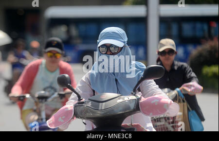 Yangzhou, cinese della provincia di Jiangsu. 16 Maggio, 2018. La gente ride di biciclette elettriche sotto il sole durante una ondata di caldo in Yangzhou, est cinese della provincia di Jiangsu, 16 maggio 2018. Onda di Calore ha colpito dello Jiangsu mercoledì con temperature superiori a 35 gradi Celsius in alcuni luoghi. Credito: Meng Delong/Xinhua/Alamy Live News Foto Stock