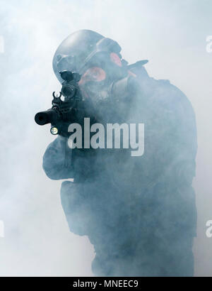 Le forze speciali militari o anti-terrorismo poliziotto armato di indossare un respiratore tenendo una mitragliatrice (poste dal modello) Foto Stock
