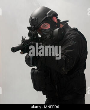 Le forze speciali militari o anti-terrorismo poliziotto armato di indossare un respiratore tenendo una mitragliatrice (poste dal modello) Foto Stock