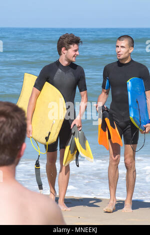 Ragazzi portano bodyboards sulla riva della spiaggia Foto Stock